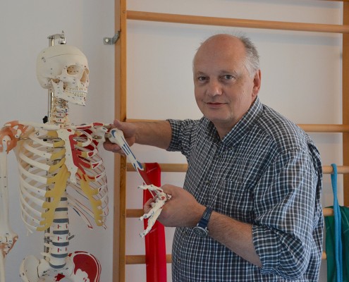 _0044_NW_G_moe_Miebs Herr Detlef Miebs steht neben einem farblich markierten Skelett und hebt den linken Arm hervor