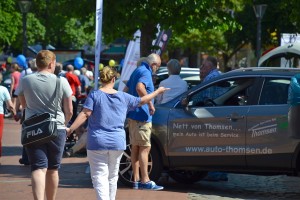 Das Foto zeigt zwei Menschen vor einem Ausstellungsmodell auf der Autoschau Tibarg 2016 in Hamburg-Niendorf am Tibarg