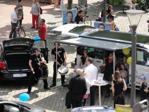 Eine Band aus Trommlern und Saxophonisten sorgt für Stimmung auf der Autoschau am Tibarg.