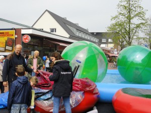 Kinder steigen in aufblasbare Bälle, mit denen sie über Wasser laufen können