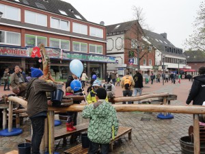 Kinder spielen mit dem Wasser, dass über offene Holzleitungen fließt.