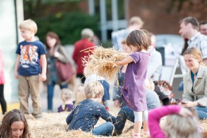 Kinder beim Spielen mit Heu auf dem Tibarg Bauernmarkt