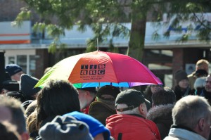 In der Menschenmenge trägt ein Besucher einen bunten Tibarg-Regenschirm.