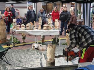 Besucher beobachten den Kettensägen-Künstler, der aus Holz Skulpturen fertigt.