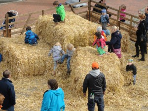 Kinder spielen auf Heuballen