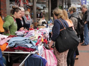 Das Foto zeigt Menschen auf dem Flohmarkt an einem Stand beim Tibargfest 2016 in Hamburg-Niendorf