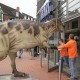 Mitarbeiter befördern ein Dinosauriermodell durch eine Tür des Tibarg Centers