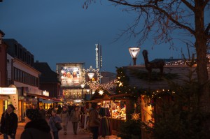 Blick auf die Einkaufsstraße am Tibarg: die Weihnachtsmarktstände sind weihnachtlich beleuchtet