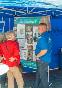 Das Foto zeigt zwei Menschen am Infostand des Bänderland Bondenwald beim Tibargfest 2016 in Hamburg-Niendorf