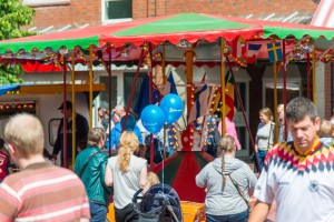 Das Foto zeigt menschen vor einem Kinderkarussel beim Tibargfest 2016 in Hamburg-Niendorf