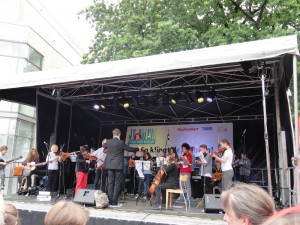 Das Foto zeigt ein Orchester mit Jugendlichen beim Tag der Musik. In der ersten Reihe stehen die Streicher.