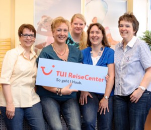 Das Team des TUI ReiseCenters mit dem Logo des Unternehmens