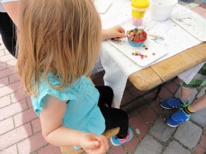 Das Foto zeigt ein kleines Mädchen beim Cup Cake selber machen auf dem Tibarg Foodtruck Festival 2016 in Hamburg-Niendorf am Tibarg