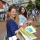 Zwei junge Frauen, die auf dem Tibarg am Shoppen sind und viele Einkaufstüten in den Händen halten.