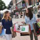 Zwei junge Frauen, die auf dem Tibarg am Shoppen sind und viele Tüten in den Händen halten.