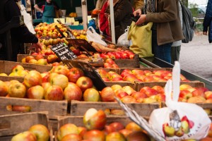 Ein Apfelstand mit vielen Holzkisten und den darin enthaltenen Äpfeln auf dem Markt am Tibarg