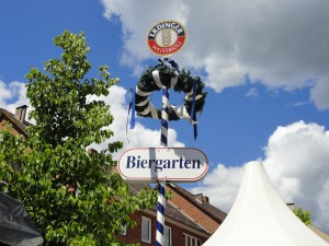 Das Foto zeigt einen Biergarten-Maibaum, im Hintergrund ist der Himmel.