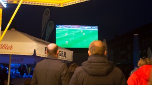 Zuschauer schauen das Fußballspiel auf der großen Leinwand