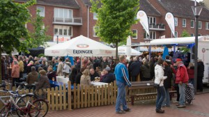 Besucher sitzen auf Bierzeltgarnituren und genießen Essen und Trinken