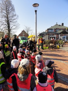 Eine Gruppe Kinder mit Warnwesten beobachtet die Einsetzung einer Tränenkiefer.