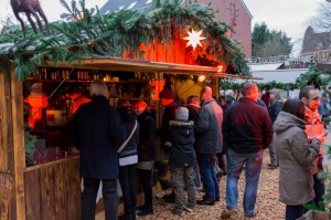 Besucher vor einem weihnachtlich geschmückten Getränkestand