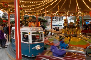 Kinder sitzen auf einem fahrenden Karussell in Autos, Flugzeugen oder Bahnwagons.