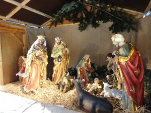 Das Foto zeigt das Krippenspiel auf dem Weihnachtsmarkt mit den Figuren aus der Weihnachtsgeschichte.