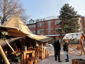 Das Foto zeigt ein Tipi-Zelt mit Sitzmöglichkeiten aus Holz. Der Platz ist leicht verschneit.