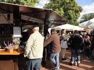 Besucher stehen vor einem Stand, der Wein und Sekt verkauft.