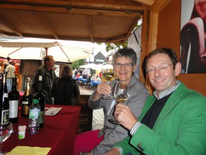 Zwei Besucher trinken ein Glas Wein an einem Stand beim Weinfest am Tibarg.