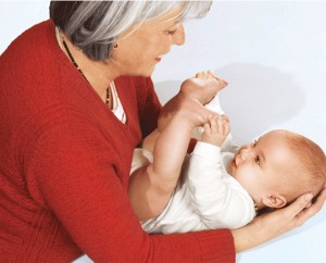 Physiotherapeutin Sabine Tötter wiegt sanft ein Baby im Arm