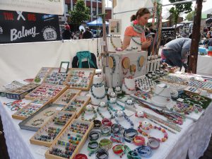 Eine Händlerin bietet selbstgemachten schmuck beim Handmademarkt auf dem Tibarg